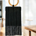 Bolso rectangular negro con flecos y asa madera