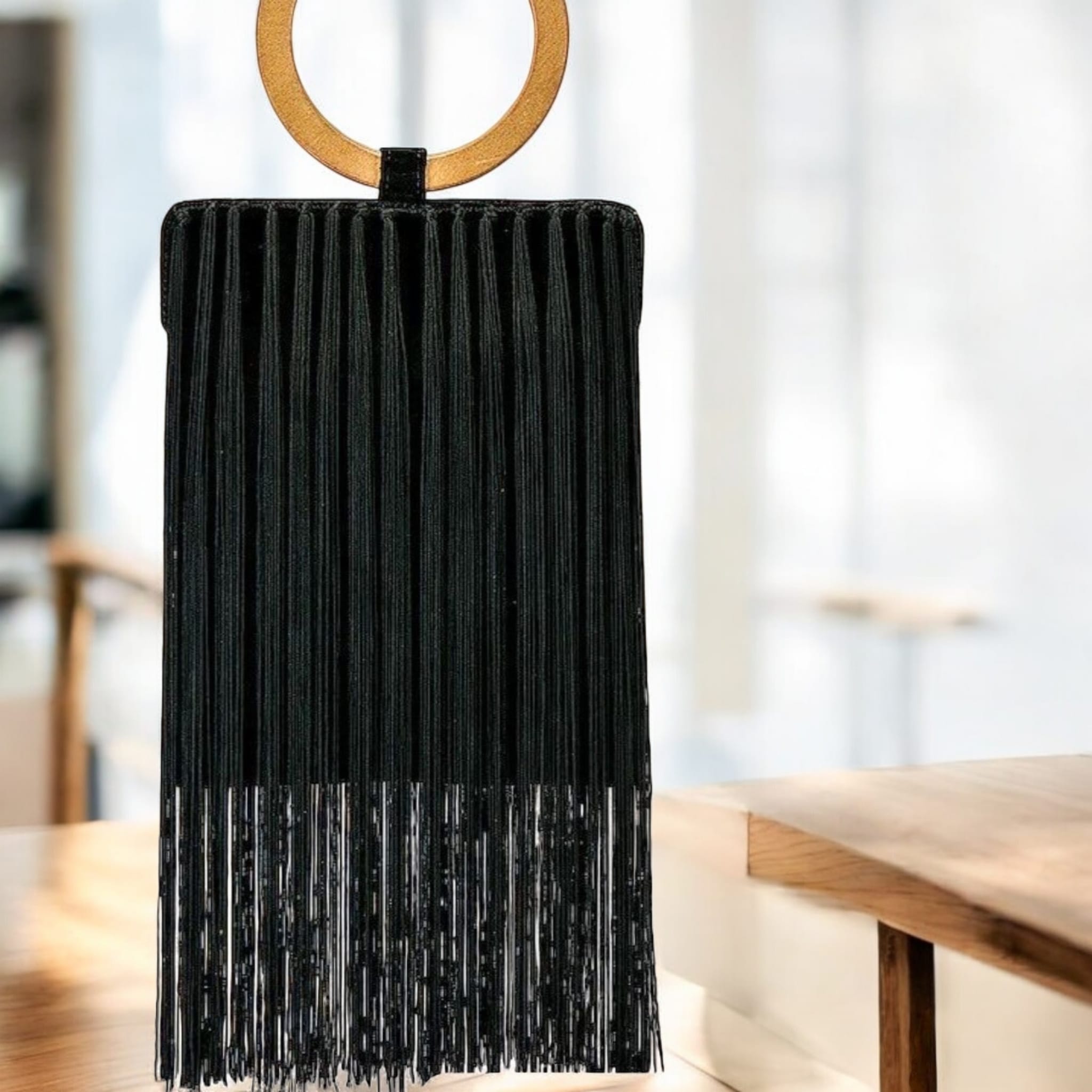 Bolso rectangular negro con flecos y asa madera