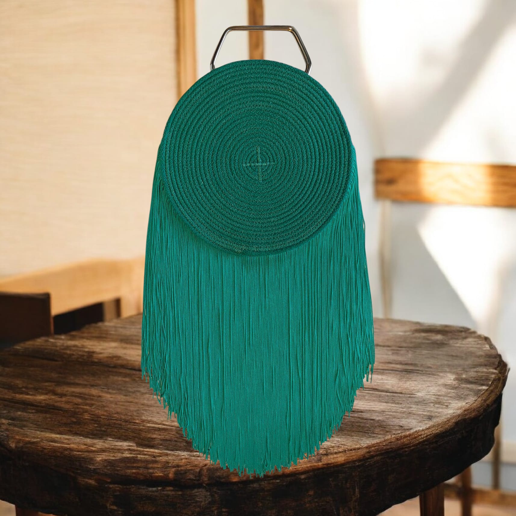 Bolso verde circular con flecos y asa dorada